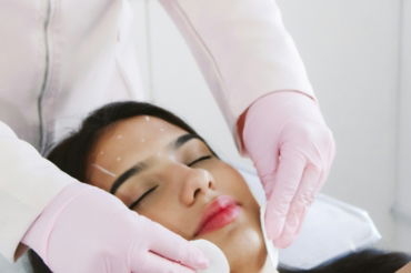 A woman getting a facial mask on her face